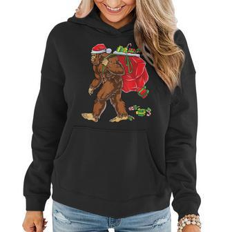 Bigfoot Santa Carrying Christmas Bag Xmas Hat Sasquatch Men Women Hoodie Graphic Print Hooded Sweatshirt - Thegiftio UK