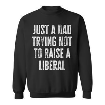 Just A Dad Trying Not To Raise A Liberal Funny Sweatshirt - Seseable